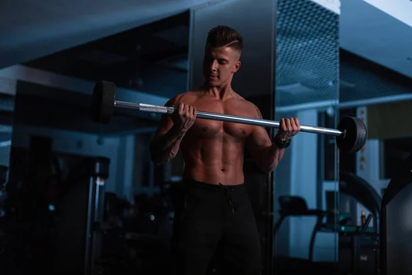 肌肉发达的年轻人 体格强壮 在黑暗的背景下在健身房锻炼 — 图库照片