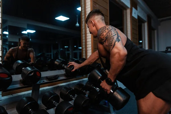 Przystojny Sportowiec Umięśnionym Ciałem Tatuażem Ramieniu Ćwiczący Hantlami Pompującymi Bicepsami — Zdjęcie stockowe