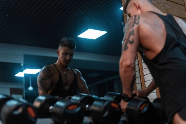 Vücut Geliştiren Yakışıklı Bir Adam Spor Salonunda Antrenman Yapıyor Dambıllarla — Stok fotoğraf
