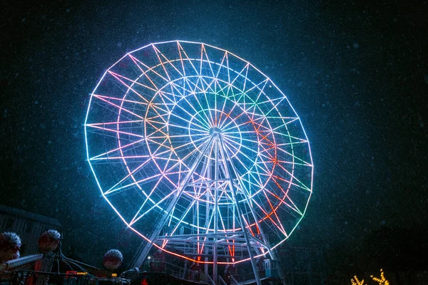 寒冷的霓虹灯摩天轮在雪天的夜晚照亮了公园 神奇的公园 — 图库照片