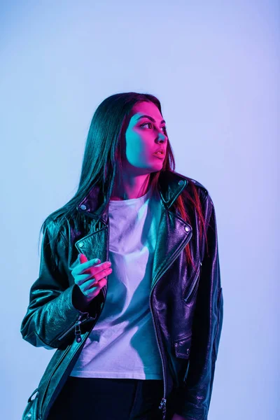 鮮やかな青と紫のライトとスタジオで黒の革のジャケットでかなりスタイリッシュな女の子のファッショナブルな色の肖像画 創造的なカラフルでスタイル — ストック写真
