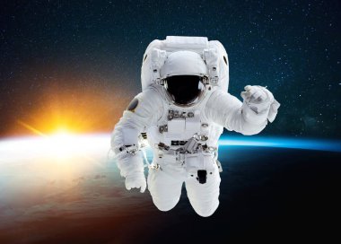 Kozmosta uçan astronot, mavi gezegenin arka planında inanılmaz bir günbatımı ve yıldızlarla birlikte. Uzay adamı görev başında ve uzayda uçuyor.