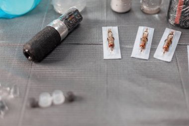 Dövme aletleri olan bir masa. Usta 'nın çalışma odası daktilo, iğne ve boya ile