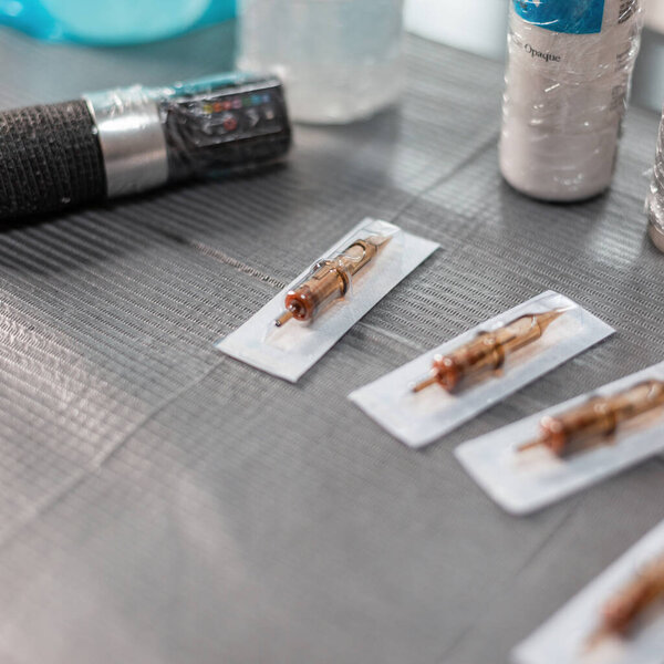 The tattoo tool is on a sterile table. Tattoo machine, needles and paint in the workspace