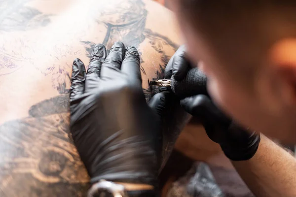 Close Mãos Masculinas Luvas Pretas Com Uma Máquina Tatuagem Faz — Fotografia de Stock