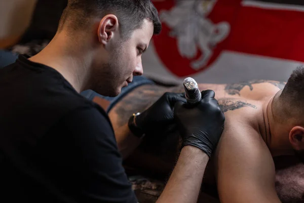 Tatuagem Artista Preenche Uma Tatuagem Nas Costas Homem Estúdio — Fotografia de Stock