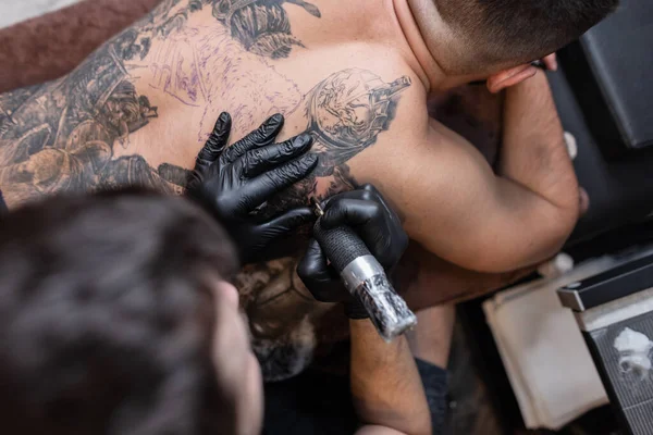 Homem Tatuador Profissional Com Uma Máquina Tatuagem Enche Uma Tatuagem — Fotografia de Stock