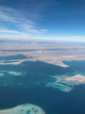 Adaları, mavi suları, karaları, dağları ve mavi gökyüzü olan uçaktan denize güzel bir manzara. Afrika üzerinde uçuş