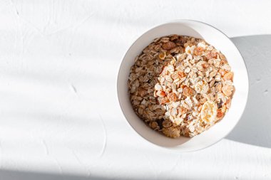 Lezzetli çiğ müsli beyaz düşünce sabahın erken saatlerinde beyaz masada