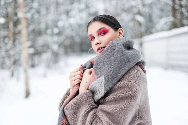 穿着时髦冬衣 头戴围巾 身穿毛皮外套 头戴雪衣的年轻貌美的女士 有着鲜艳的粉色妆容 有着眼影 — 图库照片