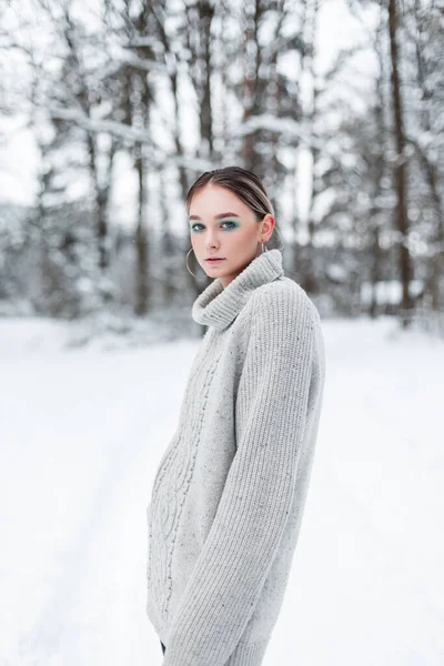 在寒冷的冬日 一位穿着时尚的老式针织毛衣的时尚女人在雪地的公园里 — 图库照片