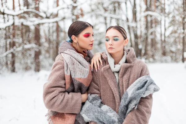 两个年轻貌美的女模特穿着时髦的衣服 毛皮外套 毛衣和带雪的老式围巾 — 图库照片
