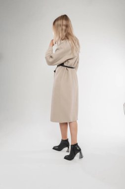 Beyaz arka planda klasik siyah deri ayakkabıları olan moda yay ceketli şık bir kadın manken. Güzel sarışın kız modaya uygun giyinmiş.