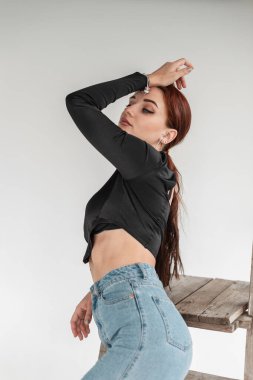 Kot giyimli güzel kızıl saçlı kadın içeride poz veriyor.