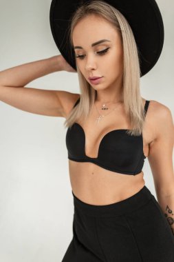 Stüdyoda sütyeni olan şık siyah şapkalı güzel, seksi sarışın kadın. Yeni moda güzel kız.