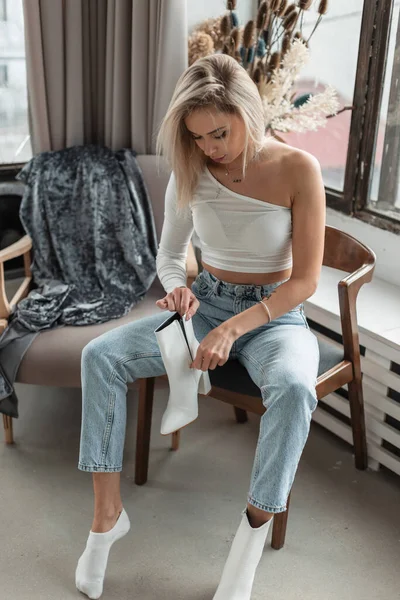 Blonde Girl Fashionable White Shirt Blue Jeans Sits Vintage Armchair — 스톡 사진