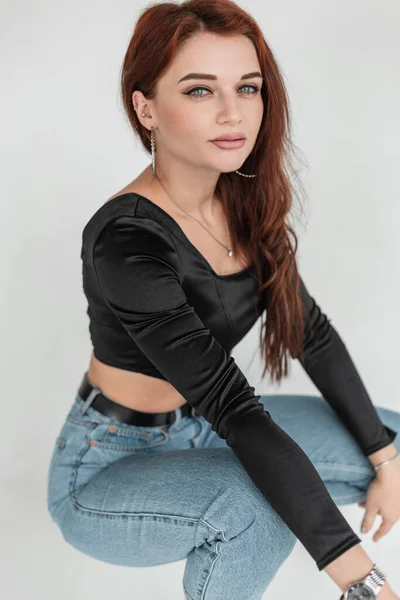 Beautiful Young Stylish Woman Black Shirt Blue Jeans Sits Poses — стоковое фото
