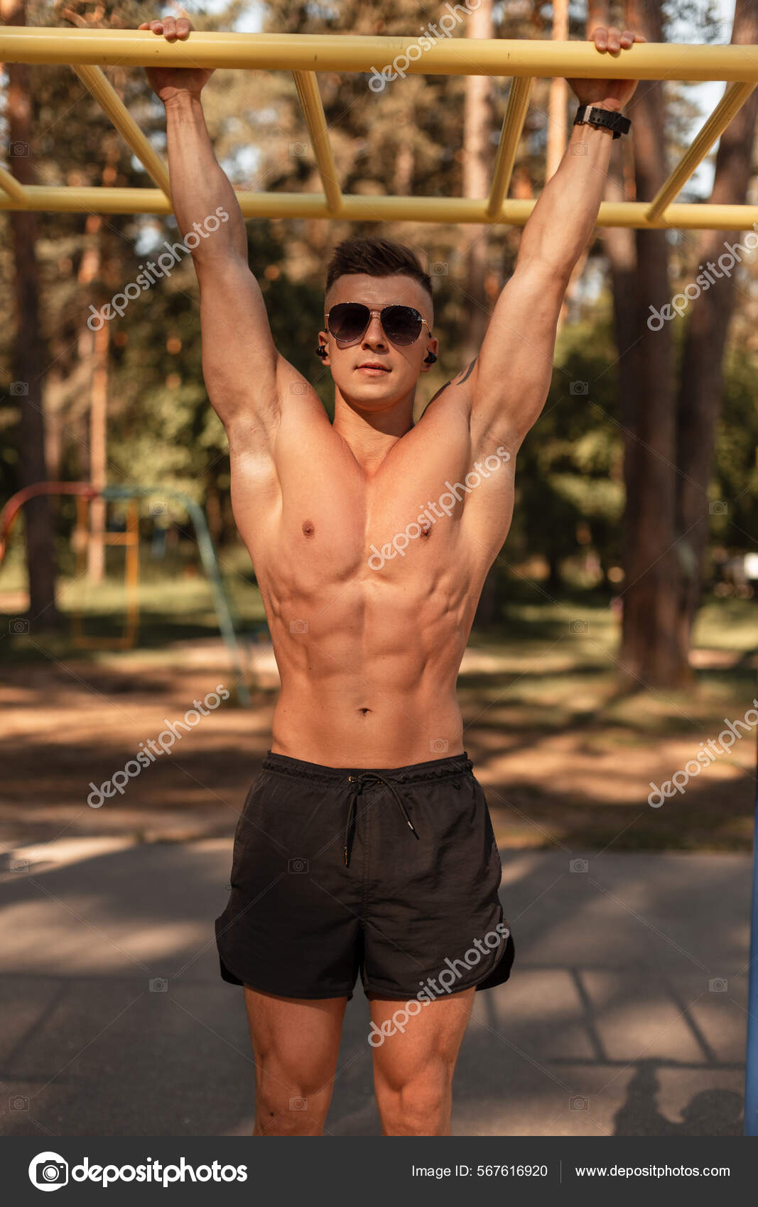 Handsome Strong Guy Athlete Muscular Body Hangs Horizontal Bar