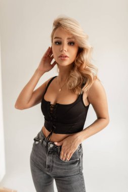 Stüdyoda beyaz bir arka planda siyah tişörtlü, şık, güzel ve seksi bir bayan.