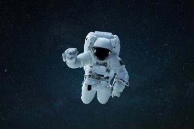 Uzayda bir astronot. Uzay adamı yıldızlarla birlikte uzayda süzülür. Uzay görevi kavramı