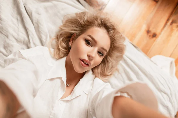 Beautiful Young Woman Blonde Hair Lying Resting Bed Taking Selfie — ストック写真