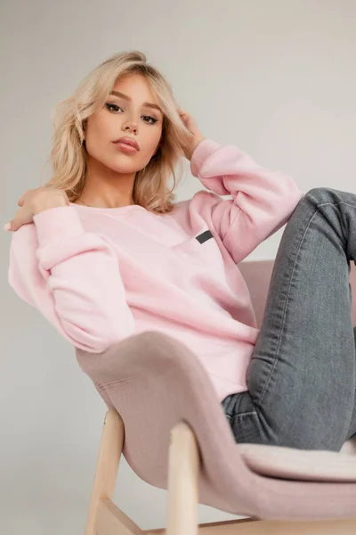 분홍색 스웨터를 청바지를 빈티지 안락의자에 유행하는 — 스톡 사진
