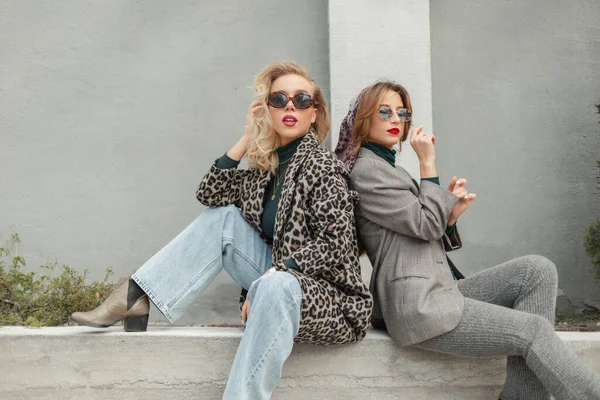 Moda modası geçmiş, havalı güneş gözlüklü iki güzel kız şehirde oturuyor.