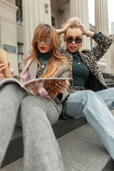 Şık Giyinmiş Çekici Genç Kızlar Şehirde Oturup Dergi Okuyor — Stok fotoğraf