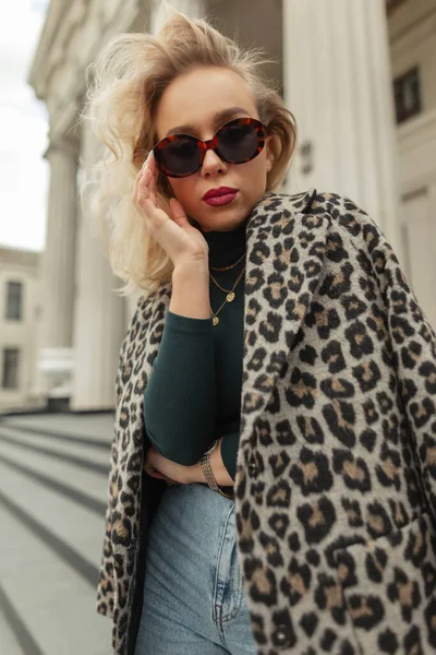 穿着时髦秋装 身穿豹衣 毛衣和牛仔裤的时髦金发女嬉皮士走在城市里 城市女性风格向外看 — 图库照片