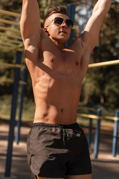 Parkta spor yapan kaslı bir sporcu.