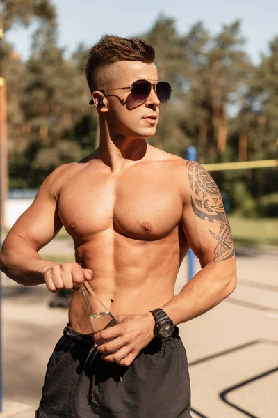 肌肉发达的年轻英俊男子 赤身裸体 在阳光下训练并在室外喝水 健康的生活方式和锻炼概念 — 图库照片