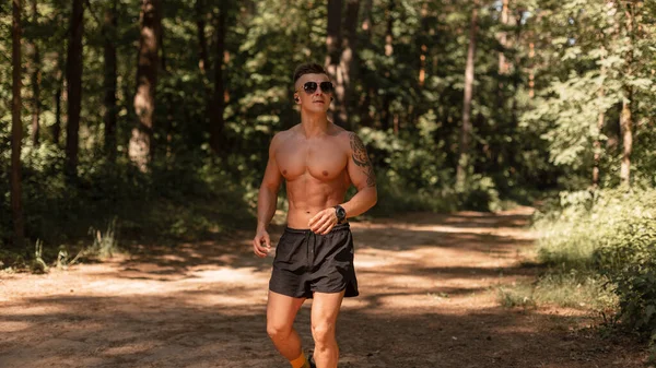 Handsome Young Sports Athlete Man Runner Sunglasses Headphones Runs Forest — Stock Photo, Image