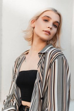 Beyaz arka planda, kısa sarı saçlı, şık yaz kıyafetli, güzel beyaz bir kız.