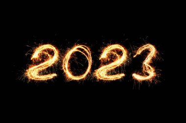 Yeni yıl 2023 ışık. Maytaplar 2023 rakamlarını çiziyor. Bengal ışıkları ve harf