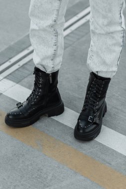 Moda kızı hippi, şık kot pantolonlar ve şık siyah ayakkabılar içinde sokakta duruyor. Kentsel kadın tarzı kıyafet
