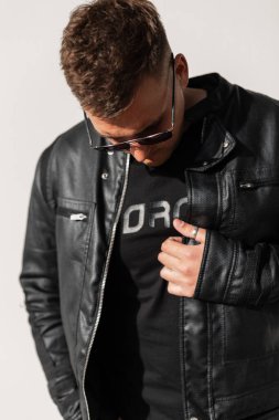 Siyah elbiseli, deri ceketli, tişörtlü ve güneş gözlüklü modaya uygun genç hippi.