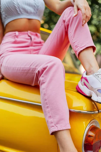 Стильна Жінка Красивими Ногами Рожевих Модних Джинсах Кольоровими Кросівками Сидять — стокове фото