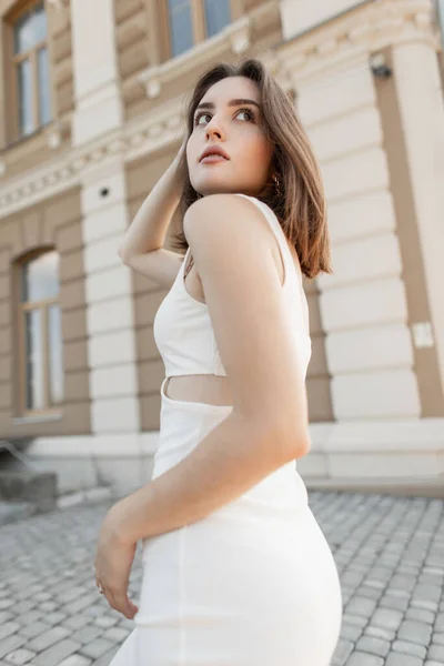 穿着漂亮的白色连衣裙 留着一头秀发的性感身材纤细的美女走在一座大楼附近的城市里 女式夏装风格 — 图库照片