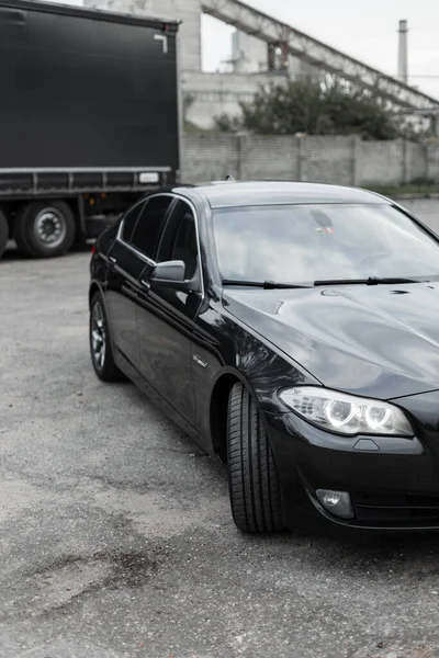 Preto Carro Esporte Moderno Estacionamento Lado Caminhão — Fotografia de Stock