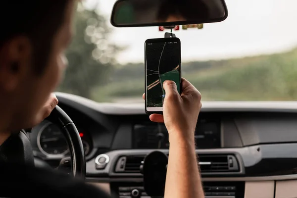 Motorista Cara Dirigindo Carro Está Segurando Smartphone Olhando Para Aplicativo — Fotografia de Stock