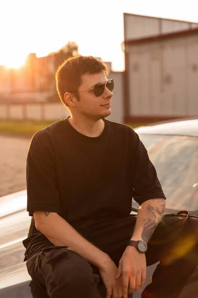 Man Hipster Modellen Met Zonnebril Modieuze Zwarte Kleren Zit Auto — Stockfoto