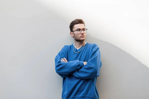 Hipster Stylowy Młody Człowiek Fryzurą Okularami Modnej Niebieskiej Bluzie Stoi — Zdjęcie stockowe
