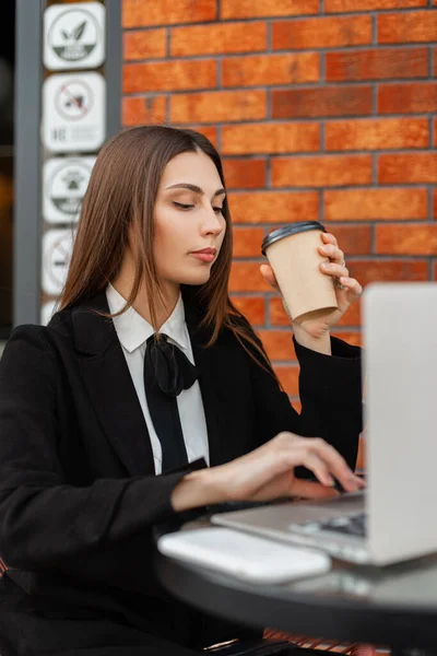 멋있는 사업가가 커피를 마시고 노트북에 텍스트를 인쇄하는 — 스톡 사진