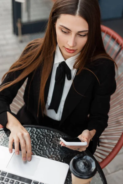 정장을 넥타이를 카페에 앉아서 전화기를 노트북으로 일하는 비즈니스 매니저 — 스톡 사진