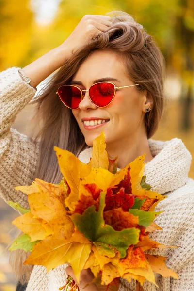 미소를 머금은 아름다운 과빨간 선글라스를 빈티지 스웨터를 가을의 노란색 오렌지색 — 스톡 사진