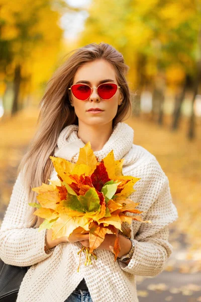 색깔의 공원을 거닐고 꽃다발이 스웨터를 멋지고 아름다운 아가씨 — 스톡 사진