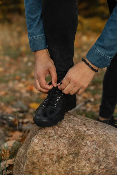 Muž Módních Šatech Zavazuje Tkaničky Skále Podzimním Parku Guy Černé — Stock fotografie