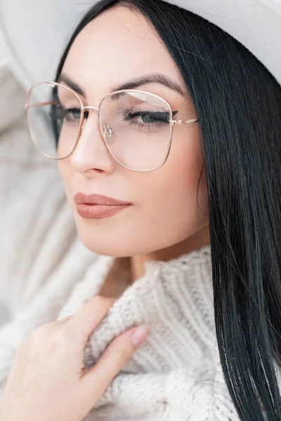 Gözlüklü, güzel yüzlü, sokakta örülmüş süveter giyen güzel bir kadının moda portresi.