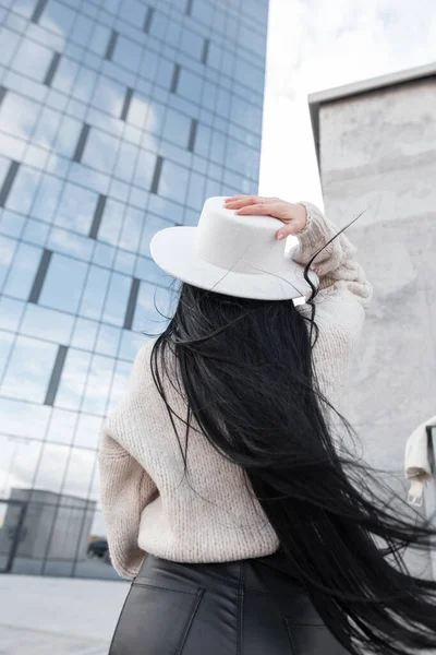 stock image Fashion happy woman with long healthy hair in casual stylish clothes with hat walks and travels in the city, back view.