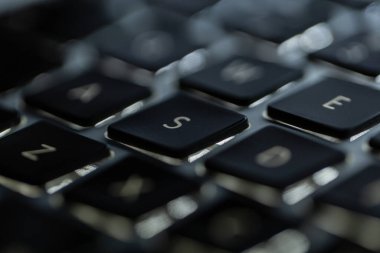 Arka ışıklandırmalı modern laptop klavyesi, A harfine odaklan.
